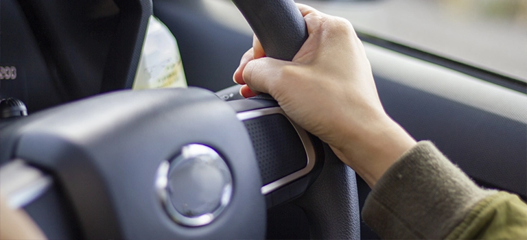 車のハンドルを握る手